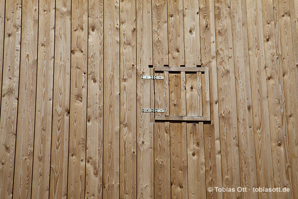 Holzfassade einer Scheune mit Fensterladen